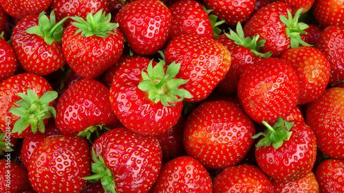 Strawberry background. Strawberries with leaves, Red fruit background. Fresh berries top view. photo