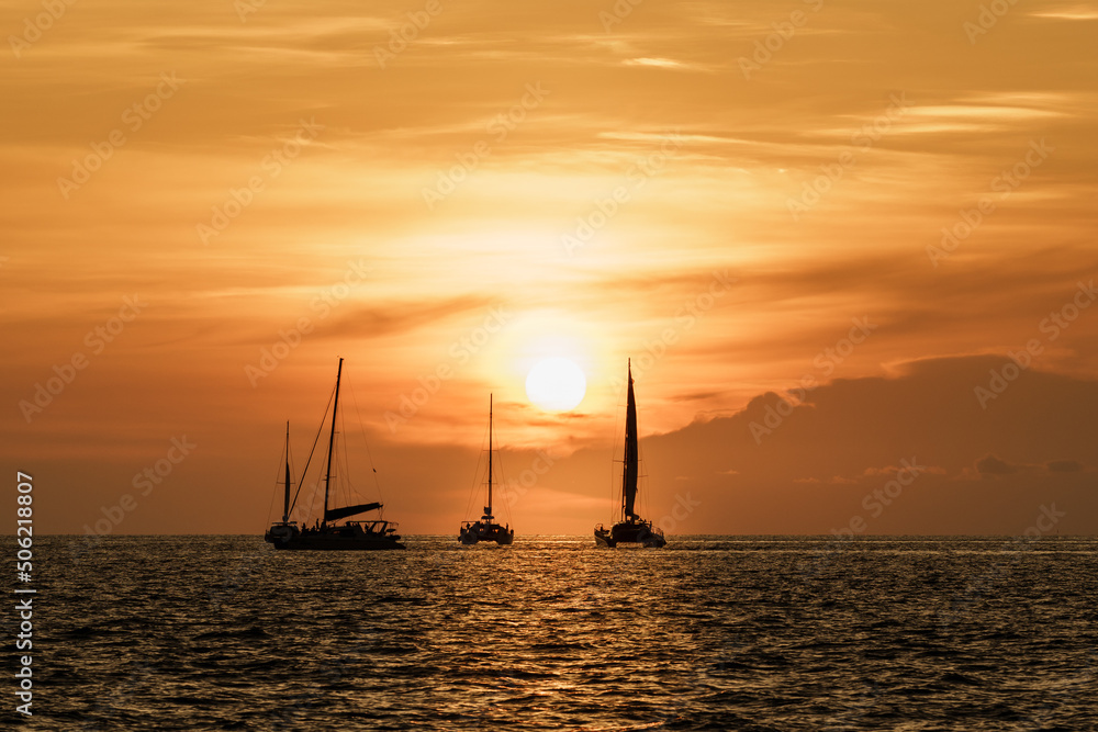 Travel activities to watch the sunset in the evening on a yacht on a romantic holiday at Andaman sea Promthep Cape, Phuket, Thailand. Leave space for text input.