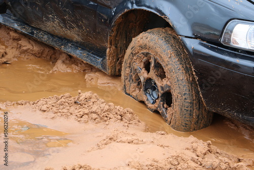 Dark blue car stuck in mud after floods caused by storm photo