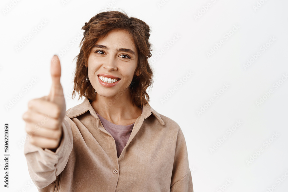 Very good. Smiling brunette girl student, hispanic woman showing thumbs up, approve like gesture, recommending, standing over white background Very good. Smiling brunette girl student, hispanic woman showing thumbs up, approve like gesture, recommending, standing over white background