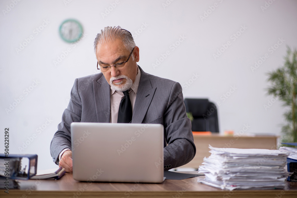 Old male employee working in the office Old male employee working in the office