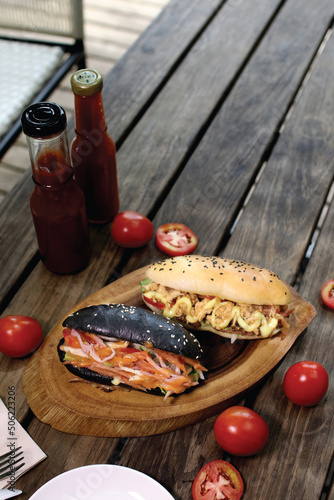 traditional burger brown and black bread on wooden plate photo