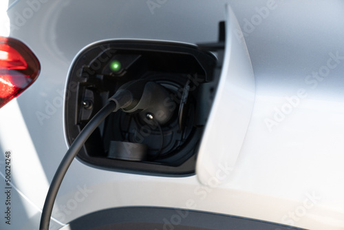 Close up of electric car with a connected charging cable 