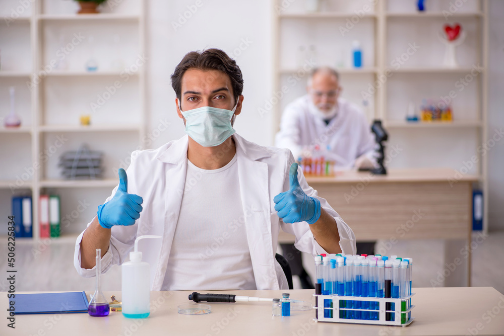 Two male chemist working at the lab Two male chemist working at the lab