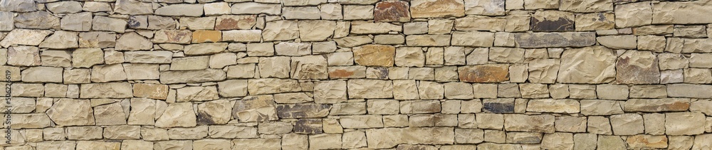 Fototapeta premium horizontal background, texture - wall of roughly hewn natural light stone