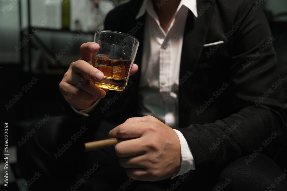 Businessman holding and pouring a glass of whiskey Businessman holding and pouring a glass of whiskey