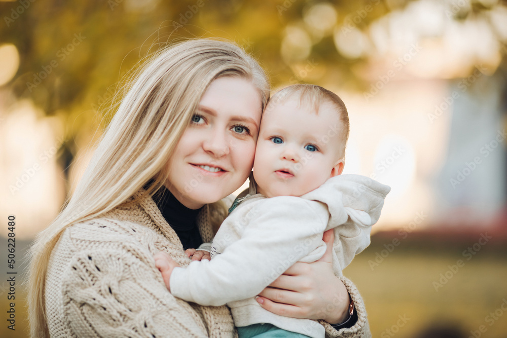 Beautiful mother and daughter walking in the park in autumn, portrait. Mom and daughter, family concept. A little girl in her mother's arms Beautiful mother and daughter walking in the park in autumn, portrait. Mom and daughter, family concept. A little girl in her mother's arms