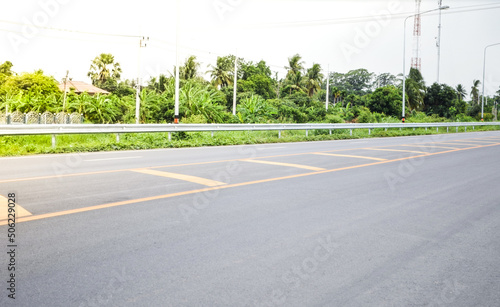 Asphalt concrete pavement road with yellow line, guardrail,traffic lane line and traffic island.Empty concrete road.