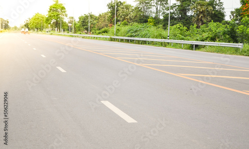 Asphalt concrete pavement road with yellow line, guardrail,traffic lane line and traffic island.Empty concrete road.