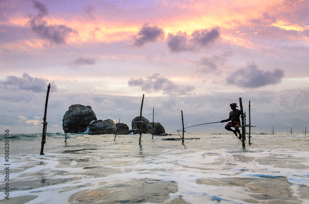 Fisherman on pole catching fish at sunset in the south of Sri Lanka