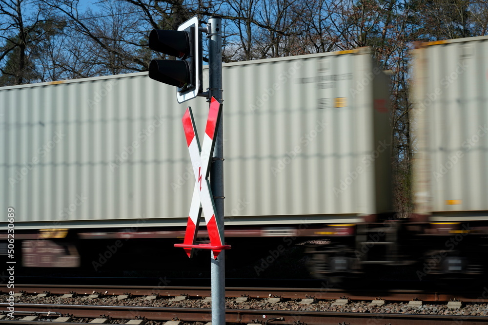 Bahnübergang mit Andreaskreuz und Güterzug