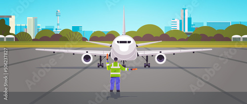 aviation marshaller supervisor in uniform signaling near aircraft air traffic controller airline worker in signal vest professional airport staff