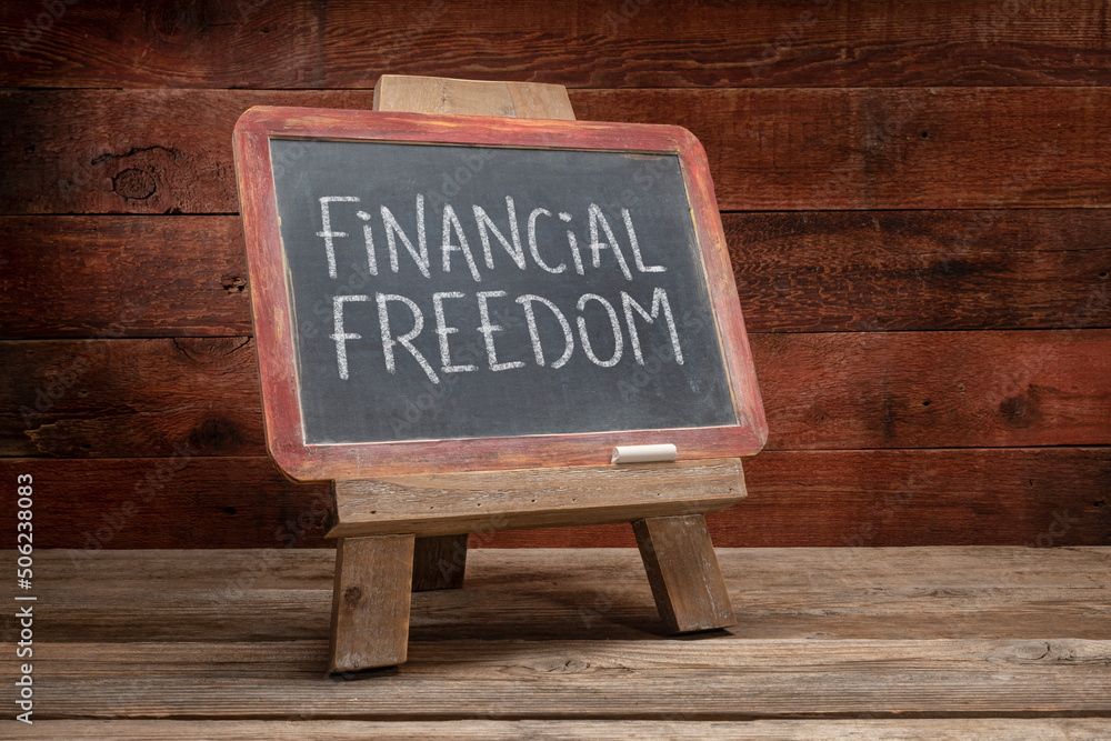 financial freedom - white chalk writing on a slate blackboard in a retro classroom, finance and personal development concept