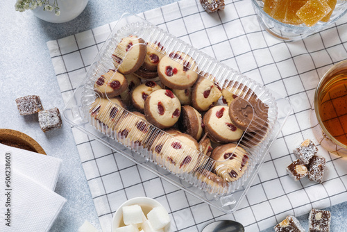 a variety of sweets, cookies and tea are on the bright table