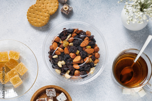 a variety of sweets, nuts, cookies and tea are on the bright table