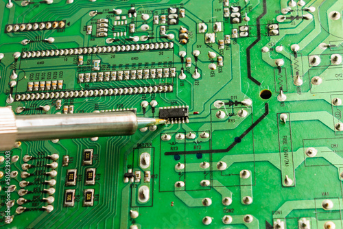Replacing electronic components and parts with a soldering iron and solder Industrial equipment. photo