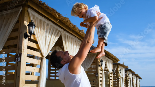 Photography dad tosses his son up at a beach resort