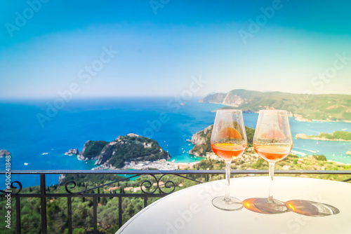 Two glasses of white wine with Corfu in background