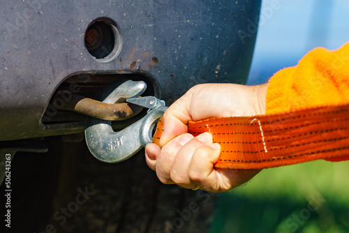Male hand attaching towline to car