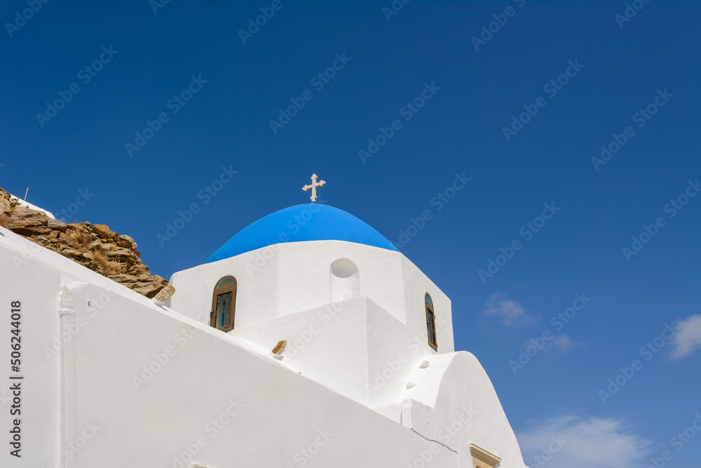 Typical Greek whitewashed church with a blue dome. Ios Island, Cyclades, Greece
