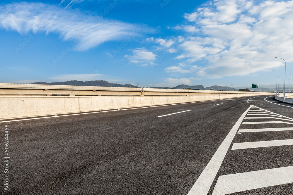 Asphalt road and mountains under blue sky. Road and sky background. Asphalt road and mountains under blue sky. Road and sky background.