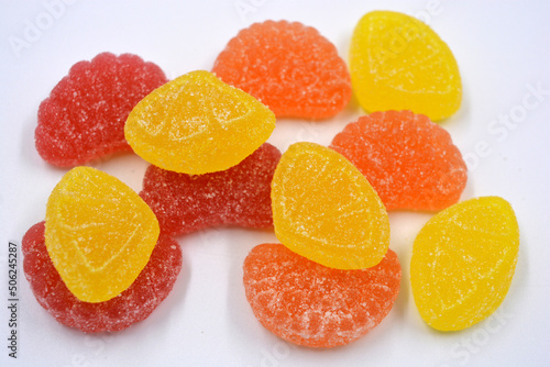 Bright, sweet, delicious yellow, orange, red, pink jelly candies located on a white background.