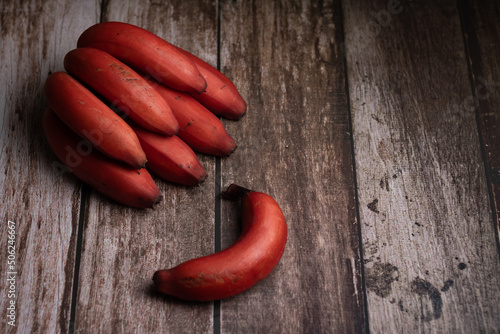 red bananas on wooden background