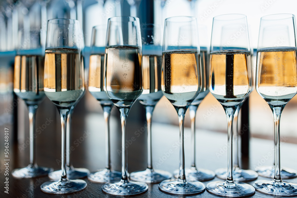 Close up photo a row of glasses filled with cold champagne lined up, ready to be served. Close up photo a row of glasses filled with cold champagne lined up, ready to be served.
