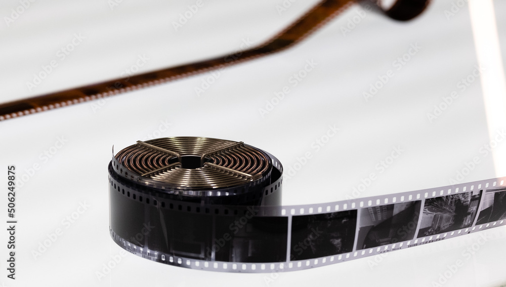 A roll of photographic film was rolled up and placed on a clear white table. placed in the center of the picture