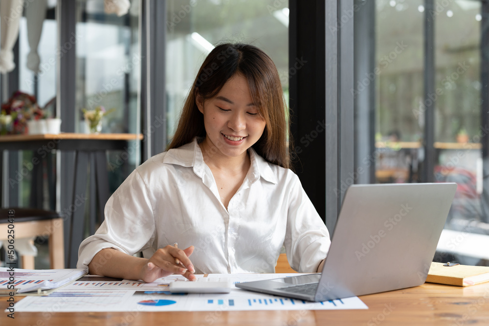 Young asian accountant hand holding pen working on calculator to calculate business data, accountancy document and laptop computer at office, business concept. Young asian accountant hand holding pen working on calculator to calculate business data, accountancy document and laptop computer at office, business concept.