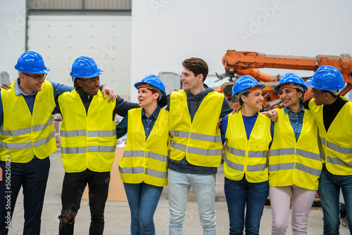 Group of workers in a robotics factory smiling