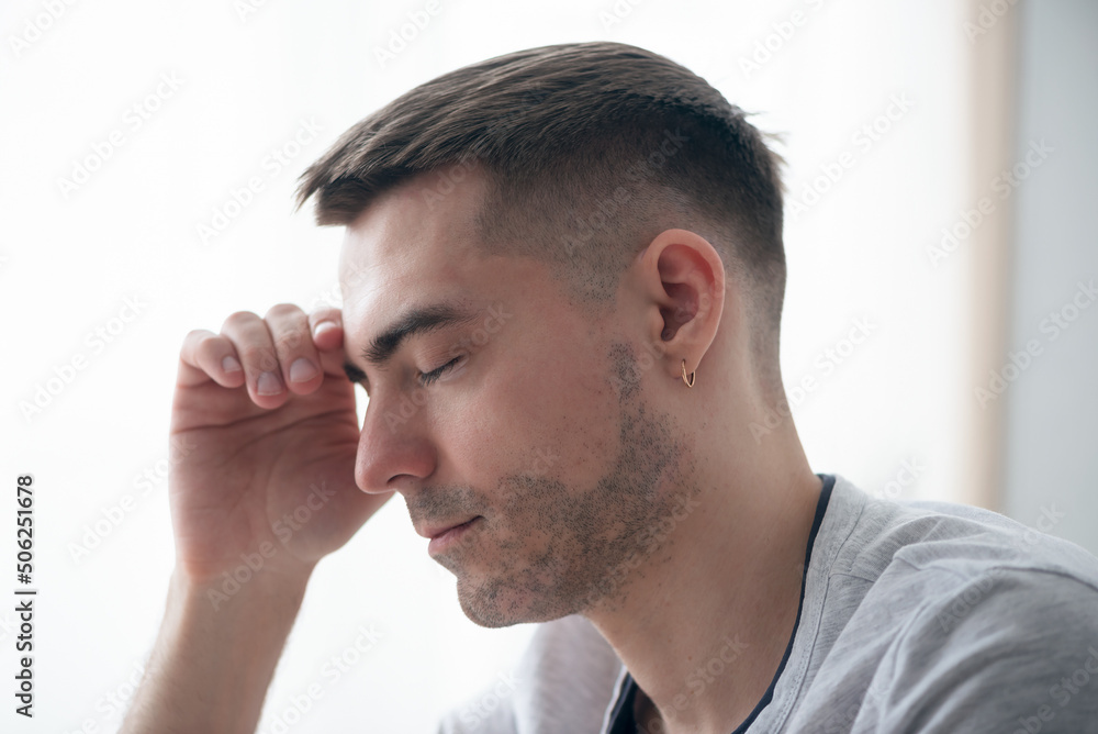 Tired man holds his head with his hand close up. Tired man holds his head with his hand close up.