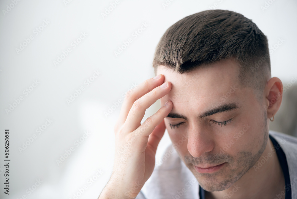 Tired man holds his head with his hand close up. Tired man holds his head with his hand close up.
