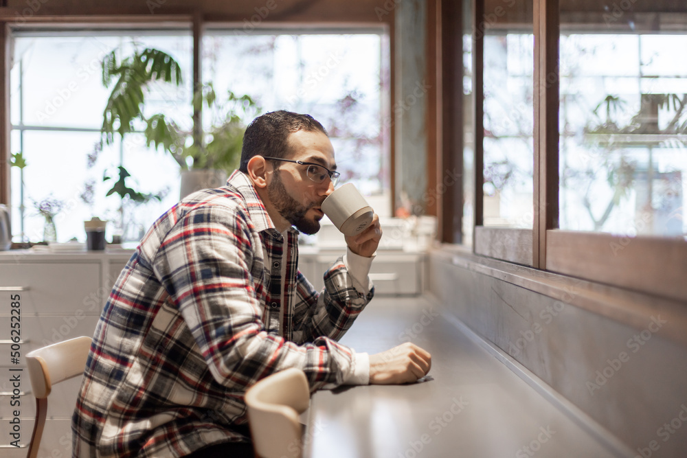カフェで一人たそがれる中東系男性 カフェで一人たそがれる中東系男性