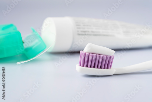 Dental care. Prevention of caries. Closed tube with toothpaste and toothbrush on a white table.