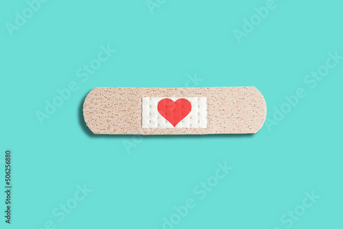 Medical patch with red heart on blue background. Abstract love concept, healing patch, broken love