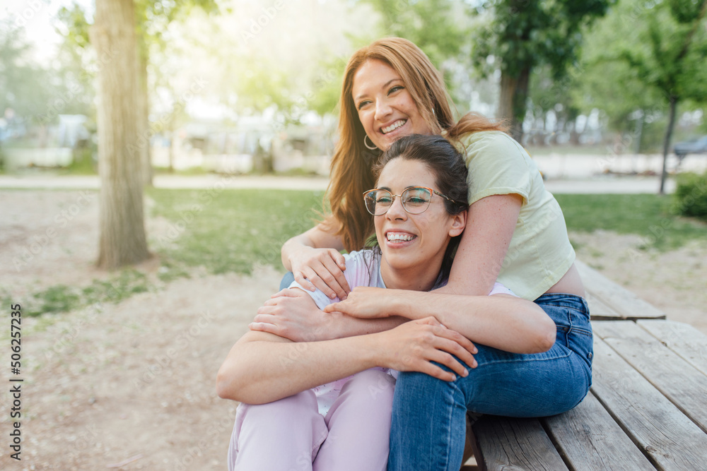 Two happy girlfriends hugging in the park. Two best friends females. Women sorority Two happy girlfriends hugging in the park. Two best friends females. Women sorority