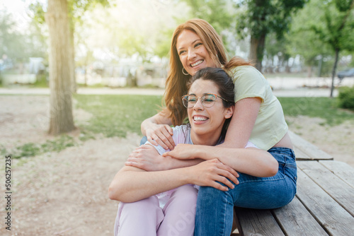 Two happy girlfriends hugging in the park. Two best friends females. Women sorority