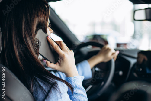Woman using phone while driving in car © Petro