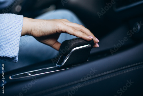 Female hand on transmission inside the car