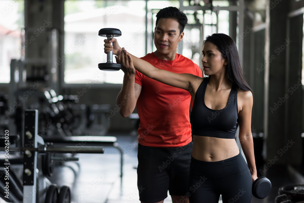 Fototapeta premium Personal fitness trainer coaching dumbbell by correct position