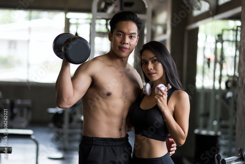 Fit sporty Asian couple portrait at fitness gym