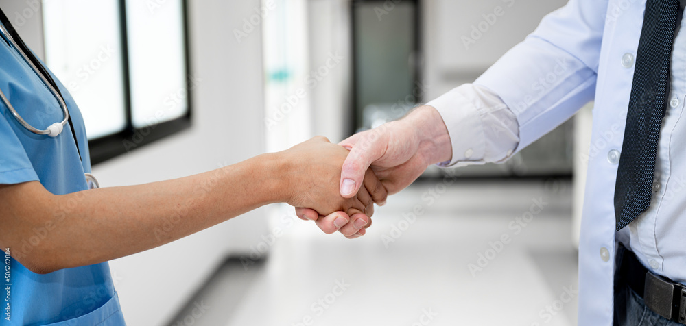 Female doctor handshake with male doctor at hospital Female doctor handshake with male doctor at hospital