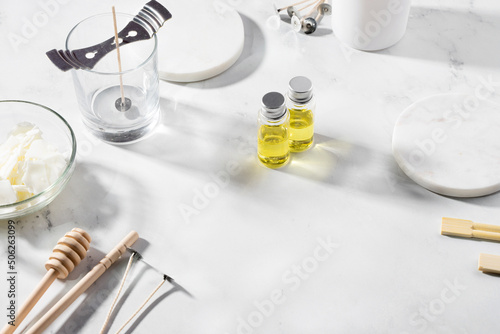 Set tools for homemade natural eco-friendly soy wax candles, wick, perfume, essential oil on a marble table. Making process. Trendy DIY. Craft hobby, small business, artisan products concept