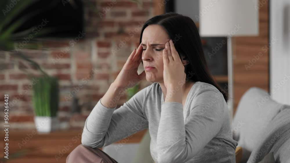 Upset young woman suffering from headache. Exhausted woman with closed eyes massaging the temples having painful sensations. Migraine, high blood pressure, chronic fatigue and eyestrain concept. Upset young woman suffering from headache. Exhausted woman with closed eyes massaging the temples having painful sensations. Migraine, high blood pressure, chronic fatigue and eyestrain concept.