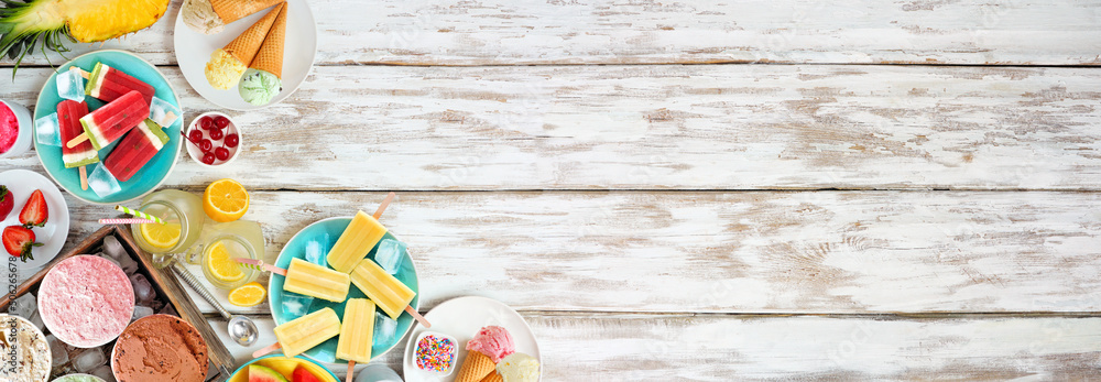 Refreshing summer foods corner border. Selection of ice cream, popsicles and fruit. Top down view over a white wood banner background.