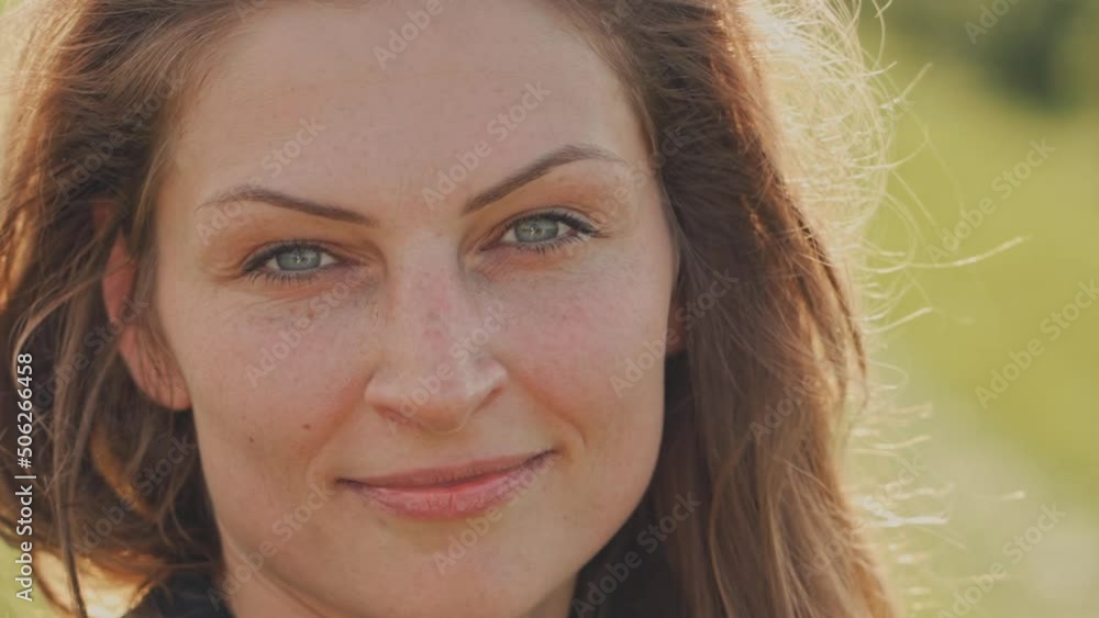 Portrait of a young charming woman with flowing hair and blue eyes. Woman looking and smiling at camera. Close-up Portrait of a young charming woman with flowing hair and blue eyes. Woman looking and smiling at camera. Close-up