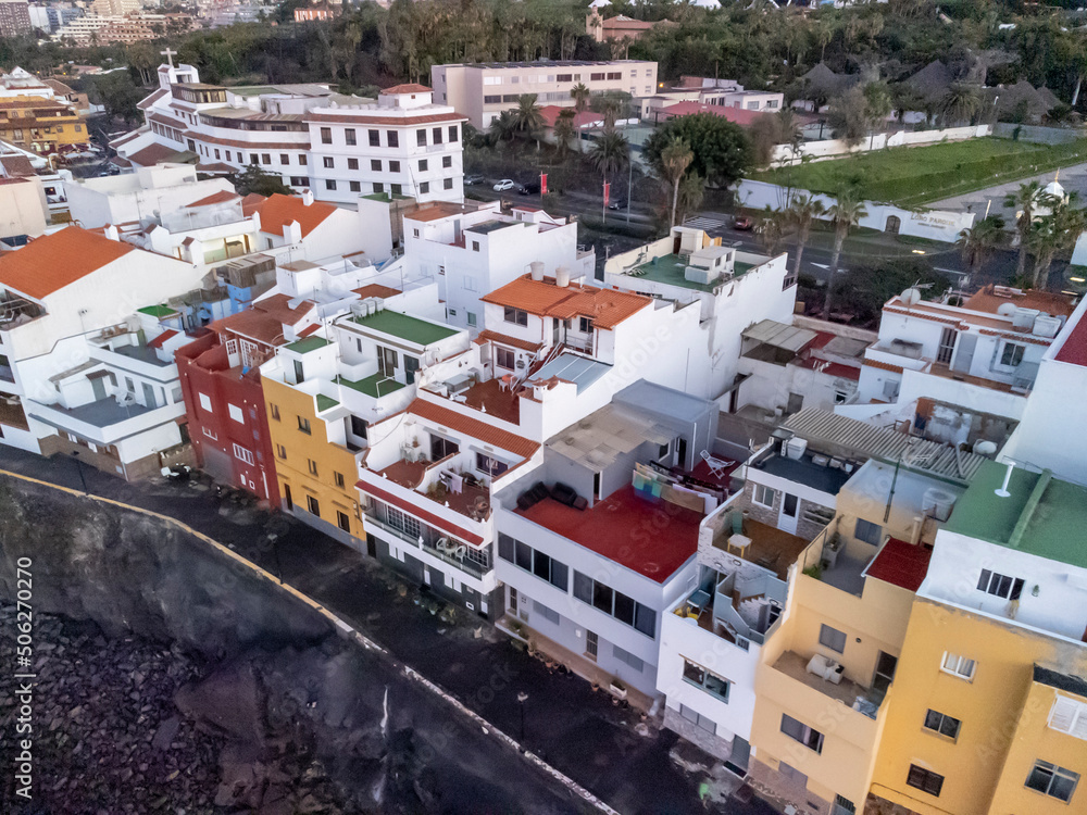 Aerial view on colorful houses and black lava rocks in small village Punta Brava near Puerto de la Cruz, Tenerife, Canary islands at sunrise