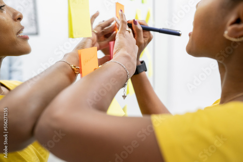 business woman in coworking writing tasks on post-it