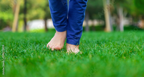 Children's feet go on the grass. Selective focus.